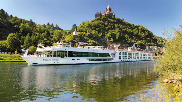 Scenic jokilaiva ja taustalla kukkulan päällä kohoaa linna.