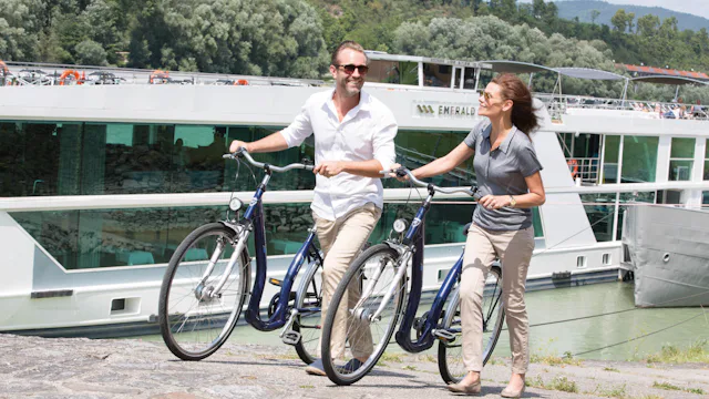 Pariskunta polkupyörien kanssa Emeraldin jokilaivan edessä.